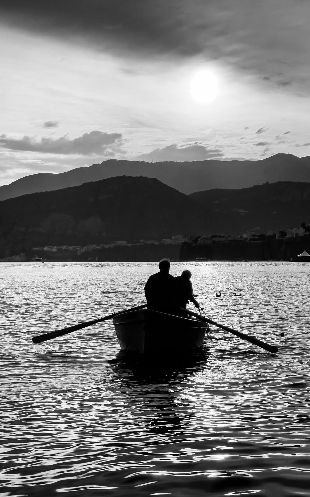 Two men rowing a boat at sunset, Sorrento