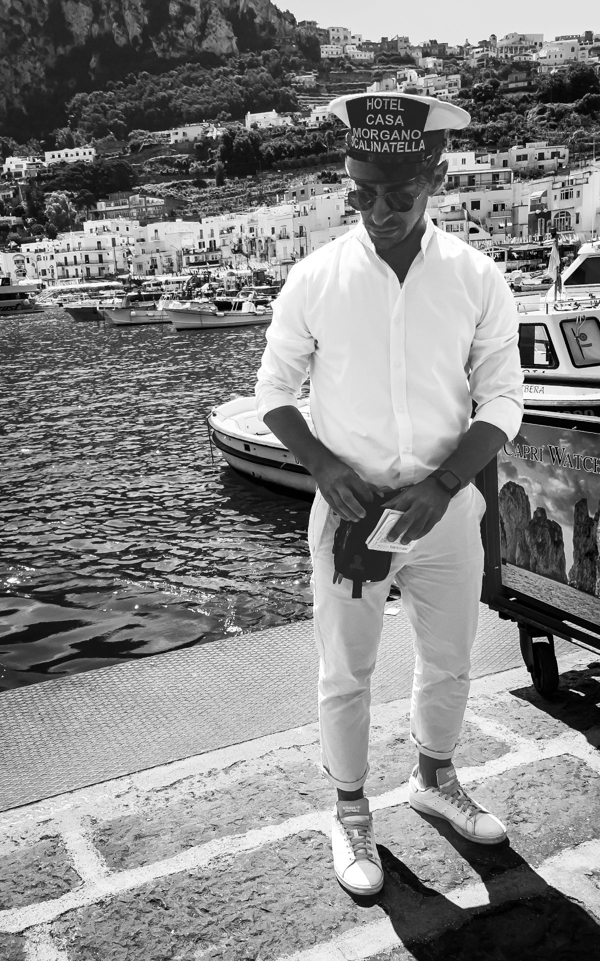 A hotel porter counting cash on the Capri harbour