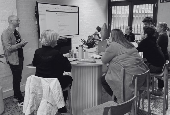 Jonathan presenting to a team gathered around a table